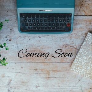 a blue typewriter on a wooden background with black text overlay stating the words coming soon.